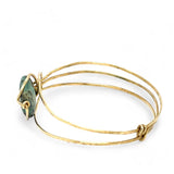 a turquoise smooth coin gemstone set in a hammered brass cuff bracelet, featuring a hand-formed clasp.