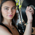 a turquoise smooth coin gemstone set in a hammered brass cuff bracelet, featuring a hand-formed clasp.