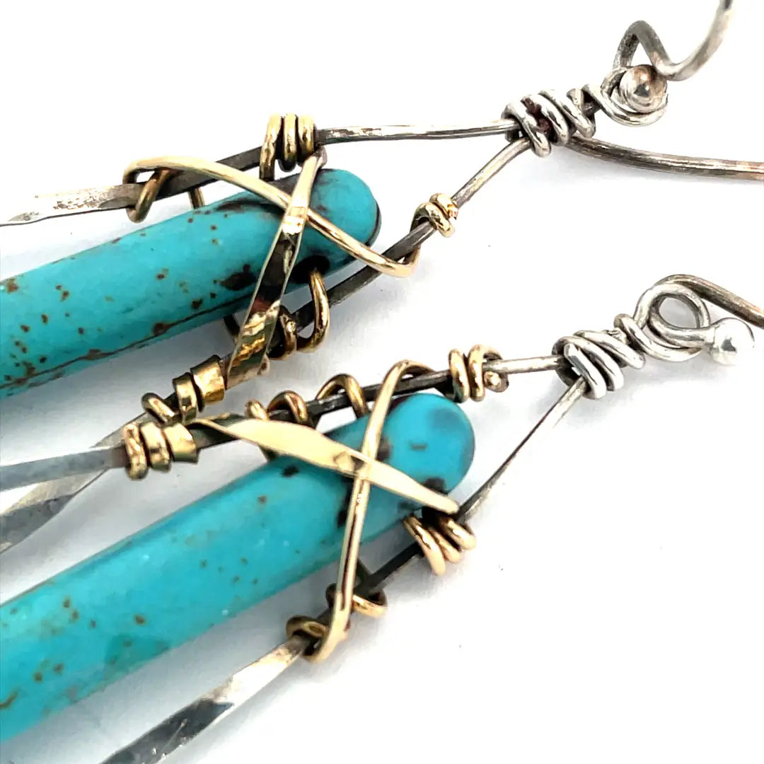 A pair of sterling silver skinny marquise earrings with turquoise stalactite on brass wire with bright blue crystal accent