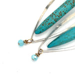 A pair of sterling silver skinny marquise earrings with turquoise stalactite on brass wire with bright blue crystal accent