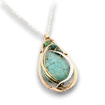 Floral stamped bronze drop pendant filled with turquoise gemstones, hammered sterling silver, and 14k gold filled wire on a sterling silver chain necklace