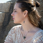 Sterling silver necklace with flashy labradorite drop gemstone and pyrite between swishes of brass wire on a delicate sterling chain with fresh water pearl accents