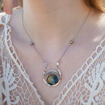 Sterling silver necklace with flashy labradorite drop gemstone and pyrite between swishes of brass wire on a delicate sterling chain with fresh water pearl accents