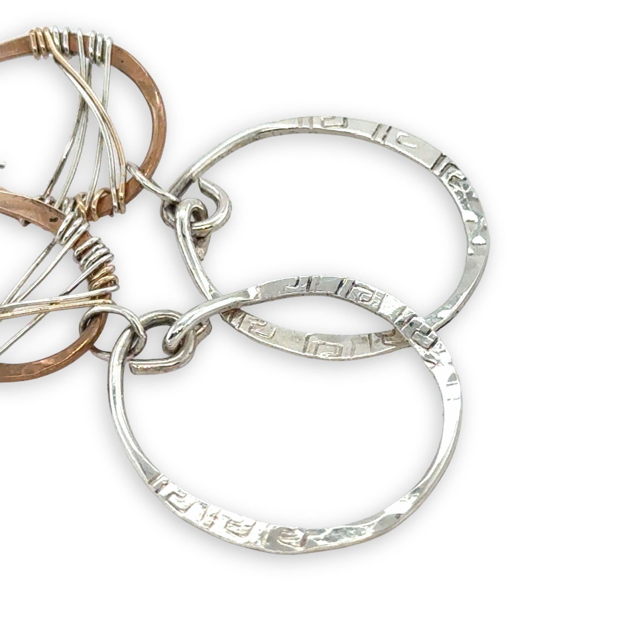 Handmade stamped sterling silver hoops hanging from bronze drops braided with sterling silver fine wire