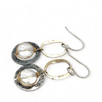 A pair of earrings featuring clear faceted quartz gemstones, oxidized sterling silver stamped rings on brass hammered handmade links.