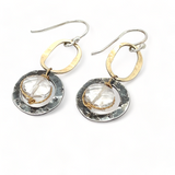 A pair of earrings featuring clear faceted quartz gemstones, oxidized sterling silver stamped rings on brass hammered handmade links.