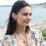 A sterling silver mini cameo pendant necklace with a salmon rhodochrosite center, wrapped in gold filled, surrounded by tourmalinated quartz gemstones. The necklace has an oxidized textured chain with hand made chain links.