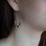 A pair of vintage style chandelier earrings with black glass and metallic crystal on bronze and twisted brass earring frames.