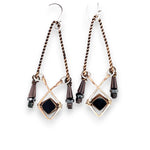 A pair of vintage style chandelier earrings with black glass and metallic crystal on bronze and twisted brass earring frames.