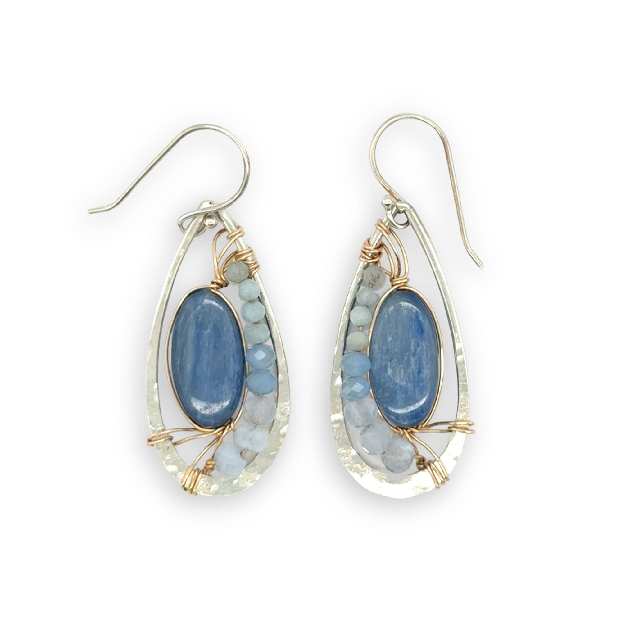 Sterling silver hammered drop earrings with smooth kyanite oval gemstones wrapped in gold fill wire surrounded by blue crystal, mini cat's eye, and blue lace agate gemstones