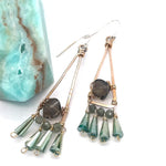 A pair of bronze triangle earrings with faceted rhomboid smokey quartz and dangles of crystal and green kyanite gemstones