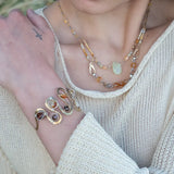 Banded brown/orange agate faceted coins are wrapped in sterling silver and gold filled wires attached to a winding river of brass hammered wire bracelet stamped with trees