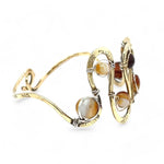 Banded brown/orange agate faceted coins are wrapped in sterling silver and gold filled wires attached to a winding river of brass hammered wire bracelet stamped with trees