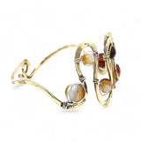 Banded brown/orange agate faceted coins are wrapped in sterling silver and gold filled wires attached to a winding river of brass hammered wire bracelet stamped with trees