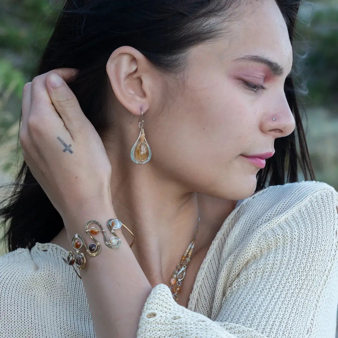 Banded brown/orange agate faceted coins are wrapped in sterling silver and gold filled wires attached to a winding river of brass hammered wire bracelet stamped with trees