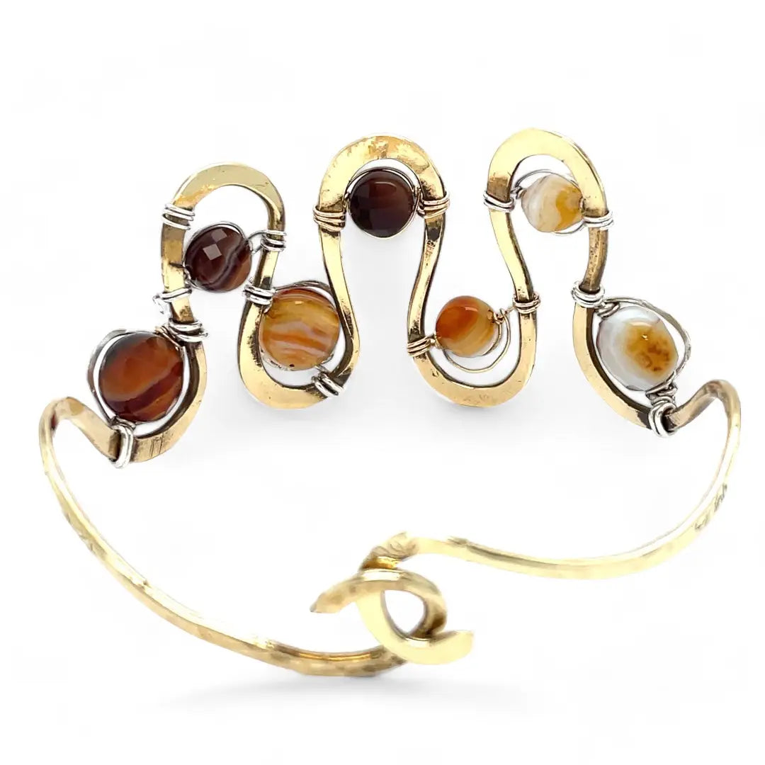 Banded brown/orange agate faceted coins are wrapped in sterling silver and gold filled wires attached to a winding river of brass hammered wire bracelet stamped with trees