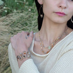 Banded brown/orange agate faceted coins are wrapped in sterling silver and gold filled wires attached to a winding river of brass hammered wire bracelet stamped with trees