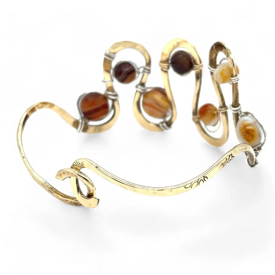 Banded brown/orange agate faceted coins are wrapped in sterling silver and gold filled wires attached to a winding river of brass hammered wire bracelet stamped with trees