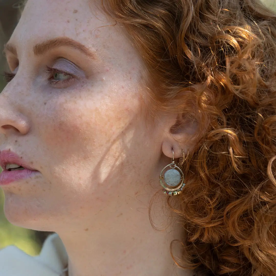 Smooth aquamarine coins are held within sterling silver mini hoops stamped with leaves with crystal accents
