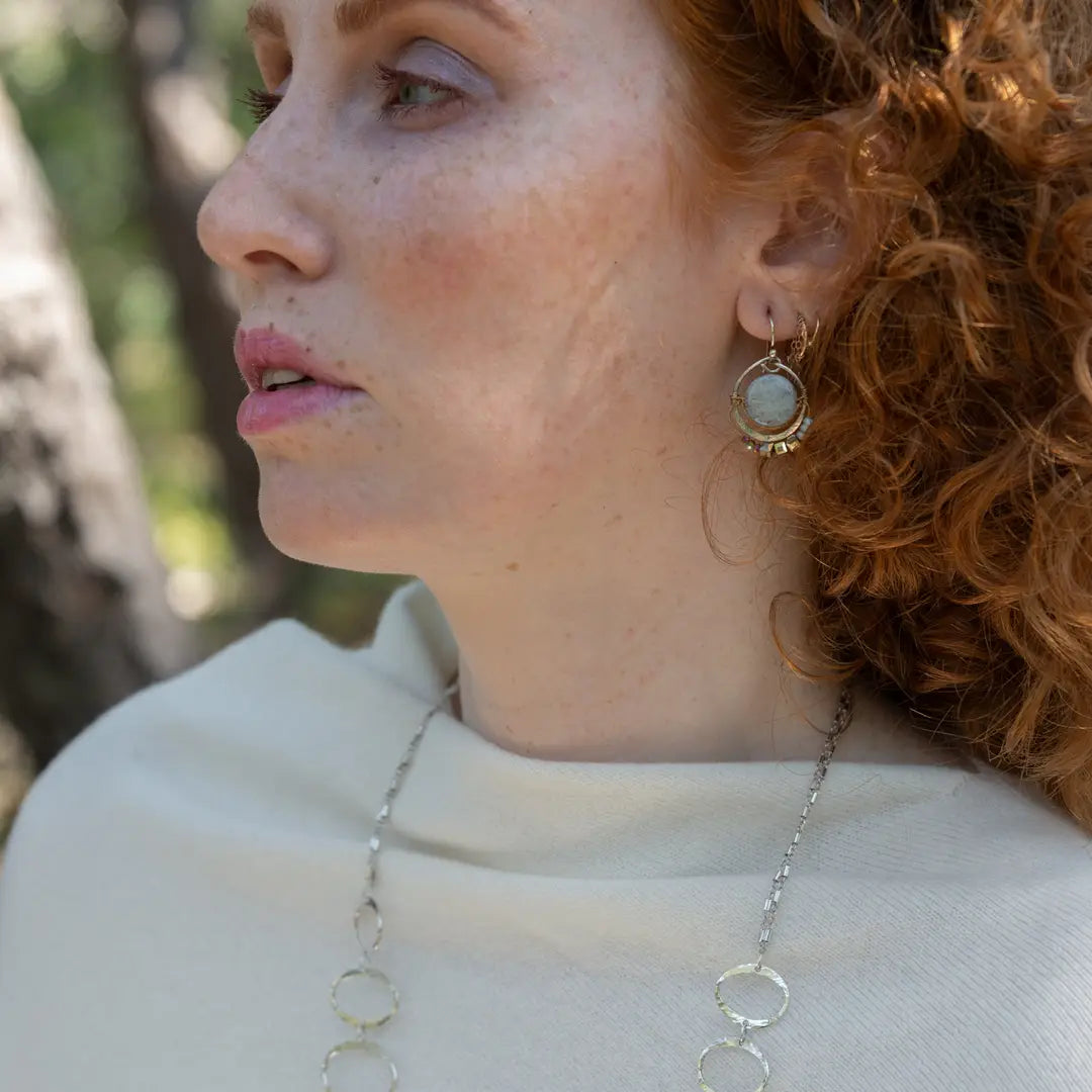 Smooth aquamarine coins are held within sterling silver mini hoops stamped with leaves with crystal accents