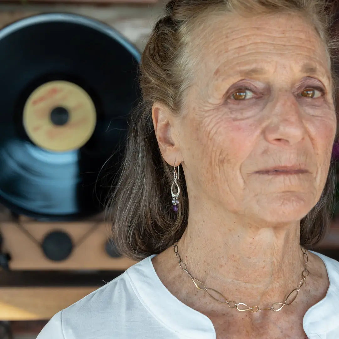 A pair of sterling silver mini drop earrings featuring faceted spherical amethyst and purple freshwater pearl accents