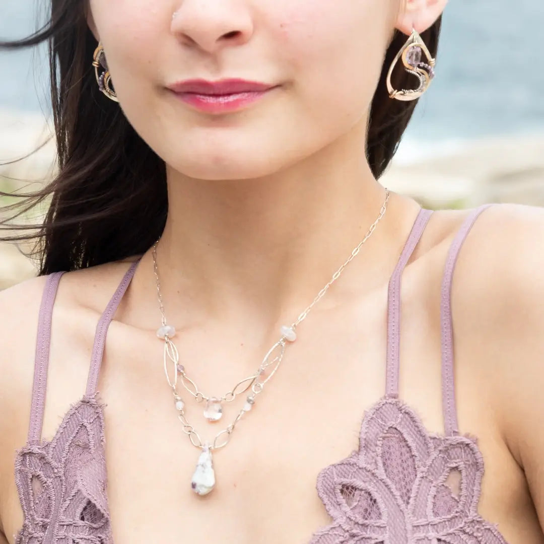 A sterling silver link chain necklace with a double strand design, featuring natural white ruby zoisite, white faceted sapphires, moonstone, amethyst, and rose quartz drops