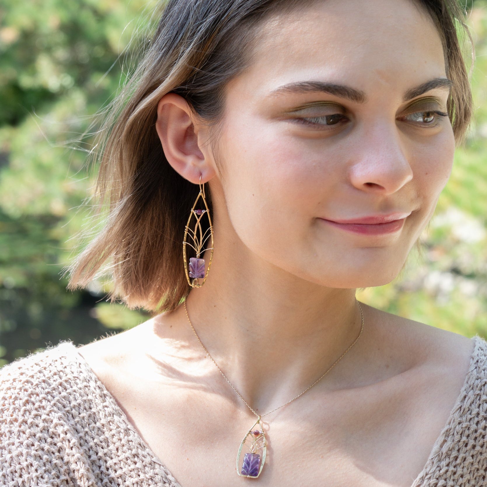 Handmade earrings featuring a carved amethyst gemstone, by Art by any Means Jewelry