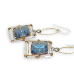 Faceted blue crystal tiles tight in brass twist wire in a stamped sterling silver box earring, hanging from gold filled link