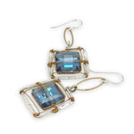 Faceted blue crystal tiles tight in brass twist wire in a stamped sterling silver box earring, hanging from gold filled link