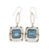 Faceted blue crystal tiles tight in brass twist wire in a stamped sterling silver box earring, hanging from gold filled link