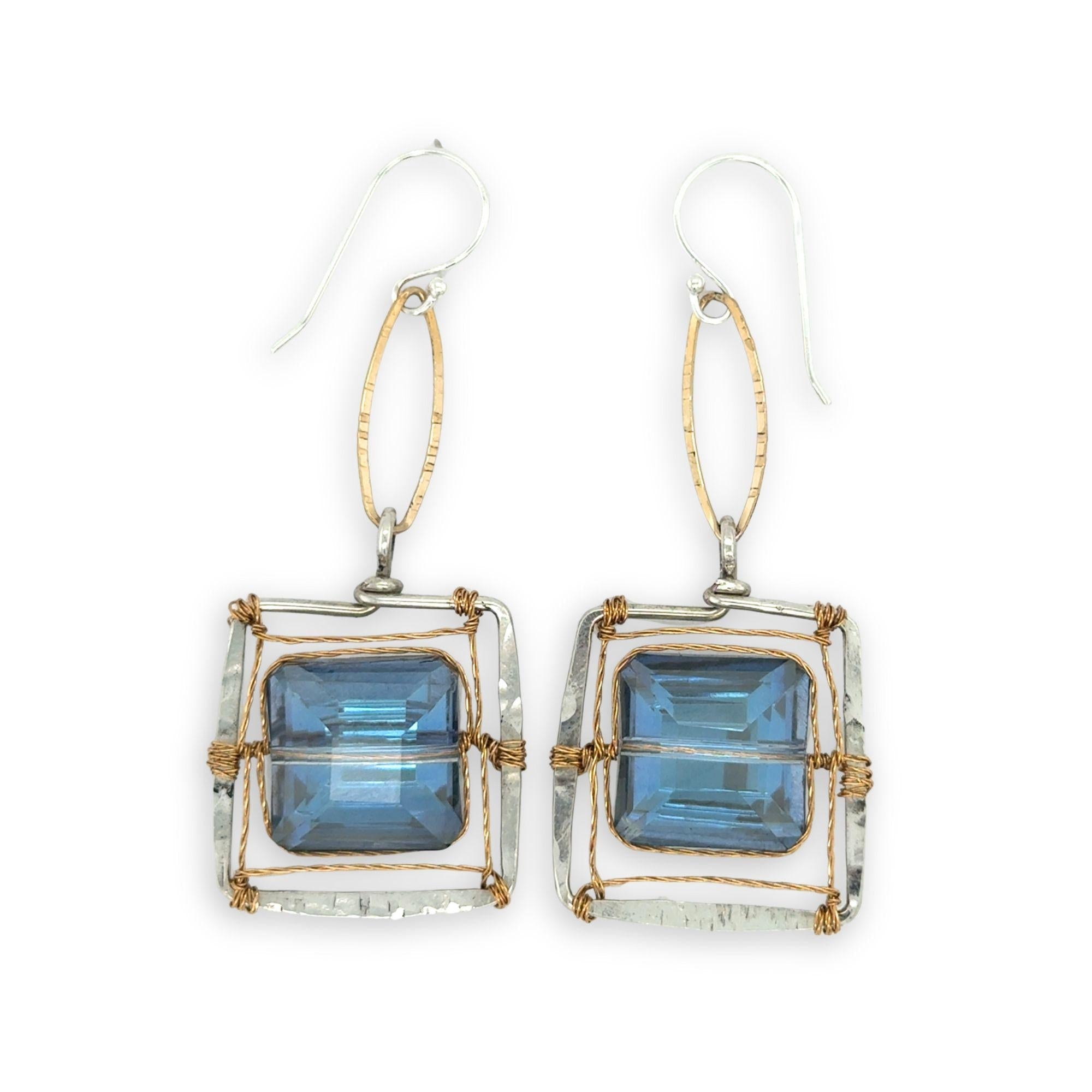 Faceted blue crystal tiles tight in brass twist wire in a stamped sterling silver box earring, hanging from gold filled link