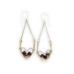 Pair of earrings with geometric design and garnet gemstones on a white background