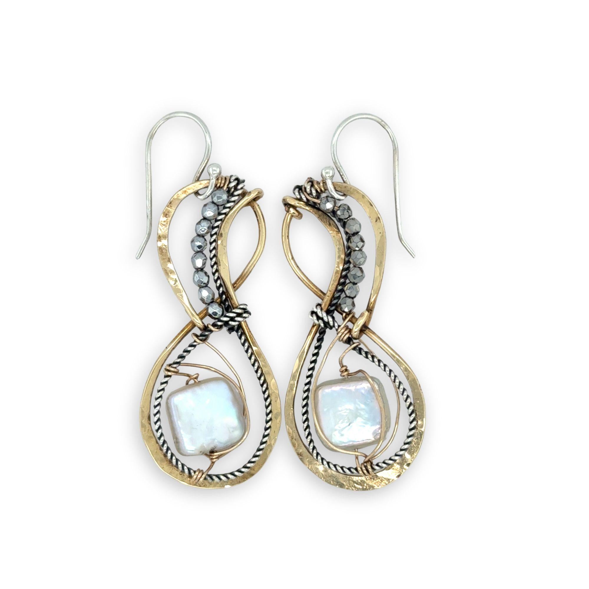 Gold and silver earrings with square pearl gemstones on a white background