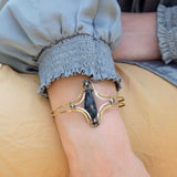 Handmade hammered brass cuff bracelet with a faceted sodalite teardrop and pyrite gemstones, by Art by any Means Jewelry
