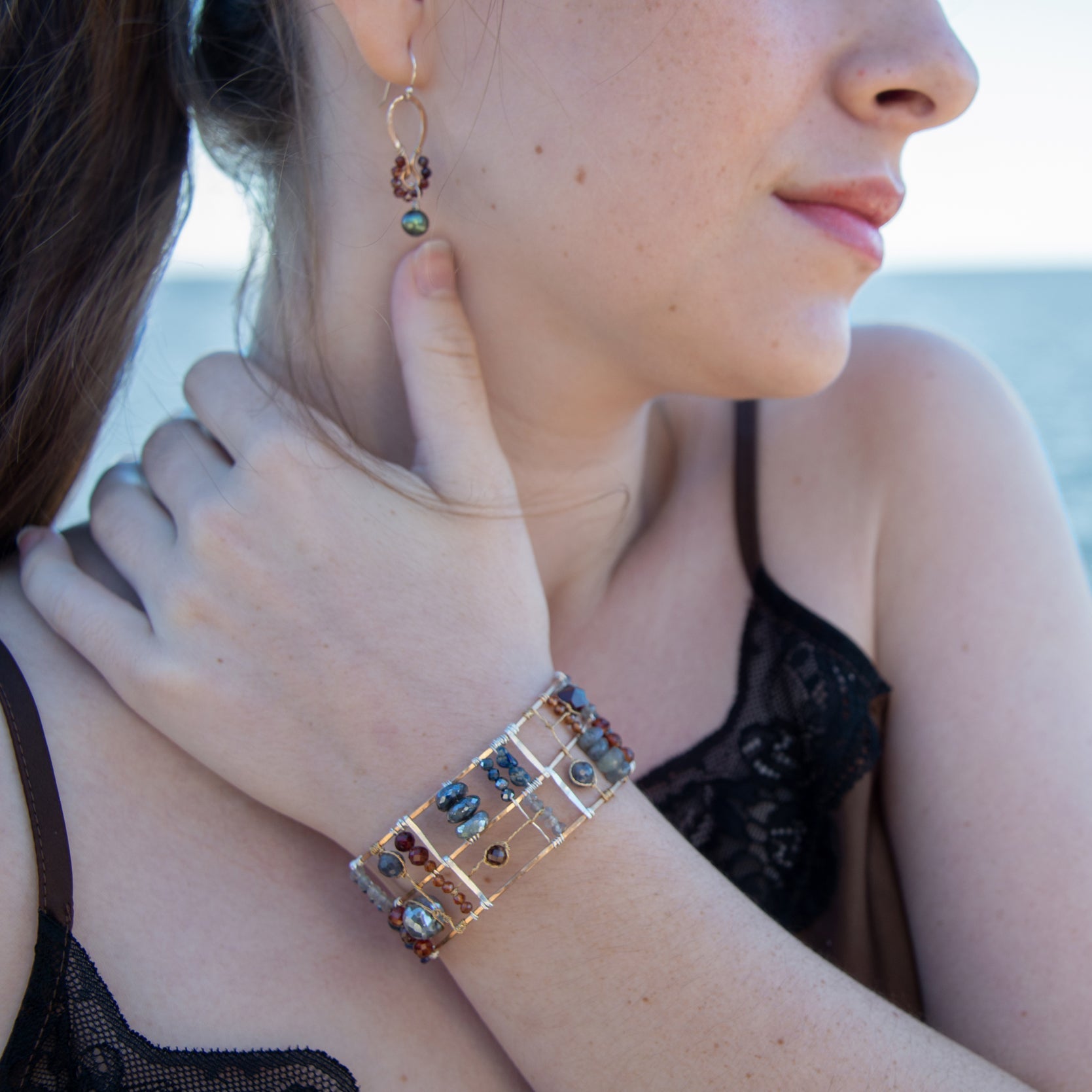 Bronze and sterling silver wide bracelet with labradorite, garnet, iolite, pyrite, and blue opal gemstones with brass accents