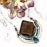 brass pendant necklace, smoky quartz , pyrite, apatite, and chrysocolla, showcased with an oval silver chain and clasp