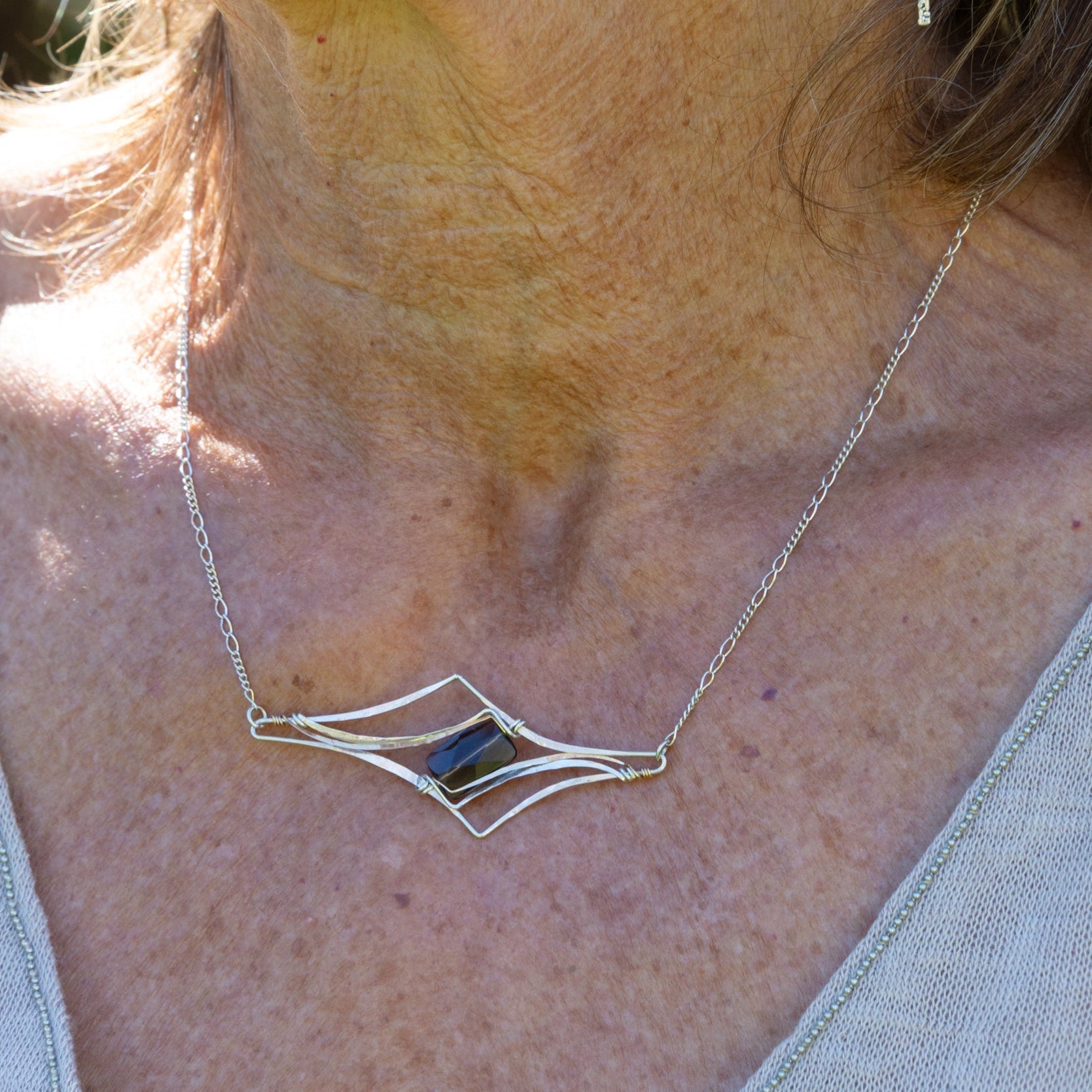 Handmade pendant necklace featuring a smoky quartz gemstone in a spire-cut design, by Art by any Means Jewelry