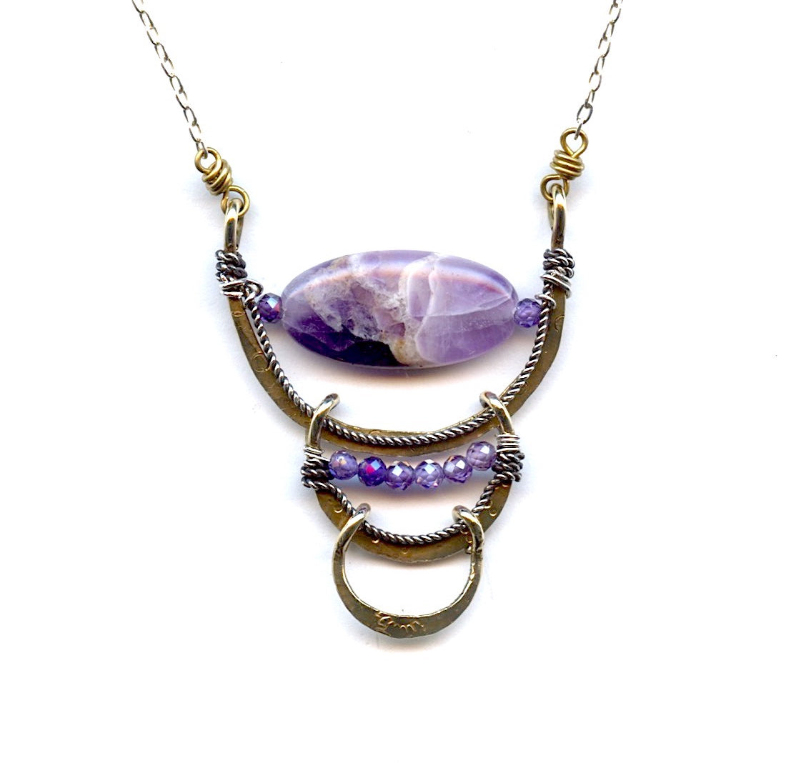 Brass and oxidized sterling silver twist layered cups necklace with a teardrop-shaped amethyst gemstone in the center, brimmed with lavender cubic zirconia gemstones on a delicate sterling silver chain