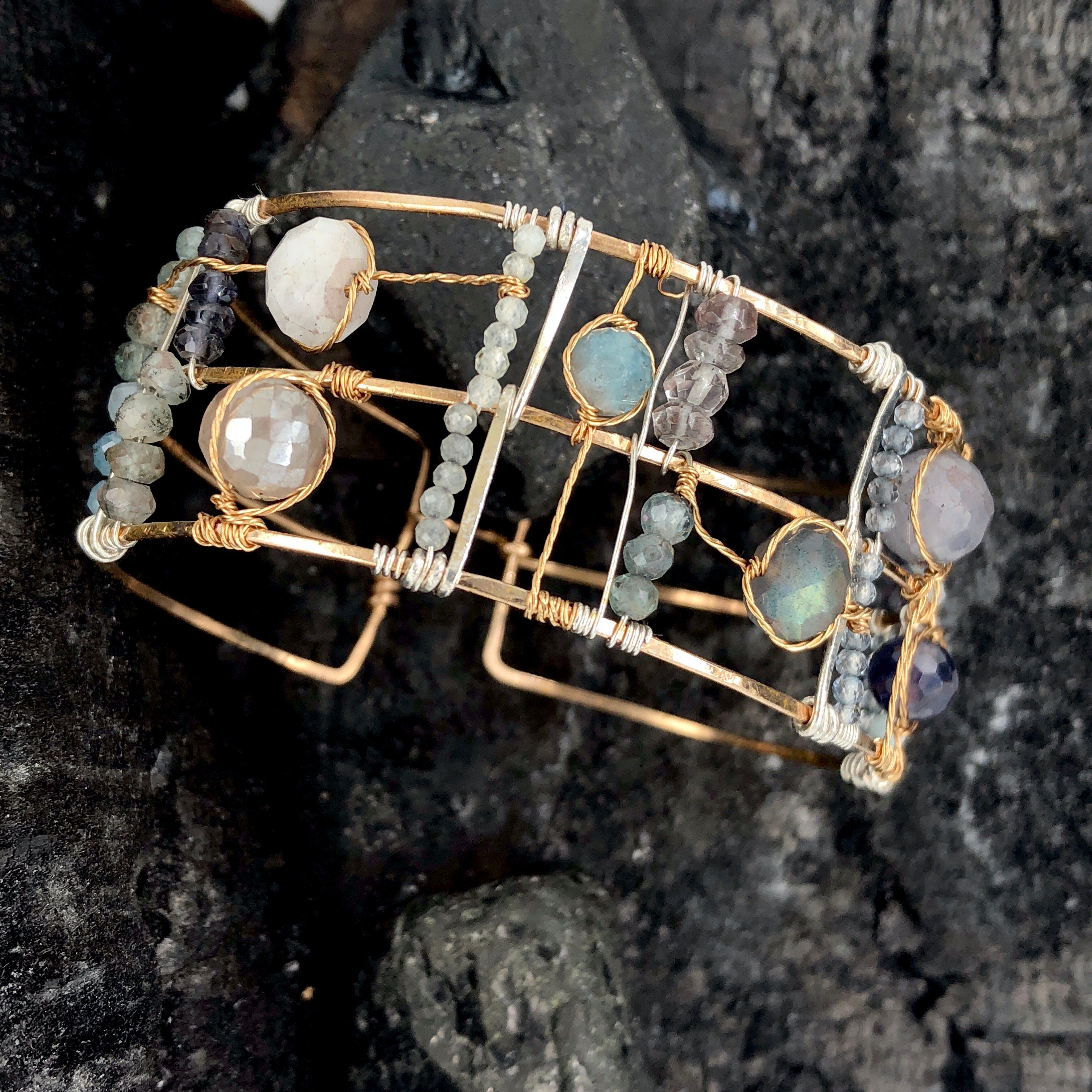 Wide bronze double cuff with sterling silver hammered bars decorated in a plaid pattern with aquamarine, moonstone, labradorite, apatite, and iolite gemstones