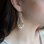 Aquamarine faceted gemstones weaved in gold filled wire along side brass hammered wire on a handmade sterling silver infinity shaped earrings