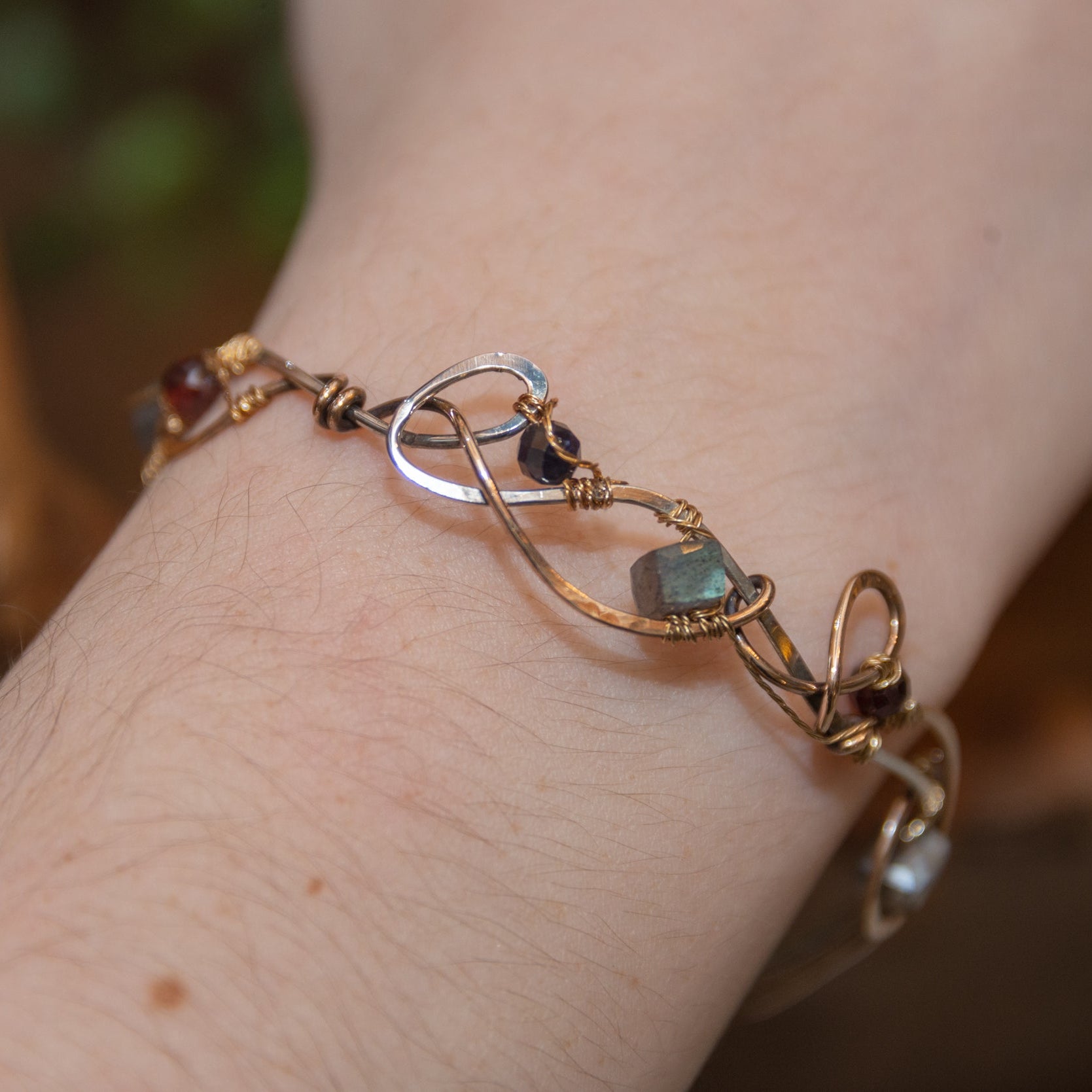 Brass and sterling silver braided bracelet adorned with  flashy labradorite cubes, hessonite garnet, and iolite gemstones