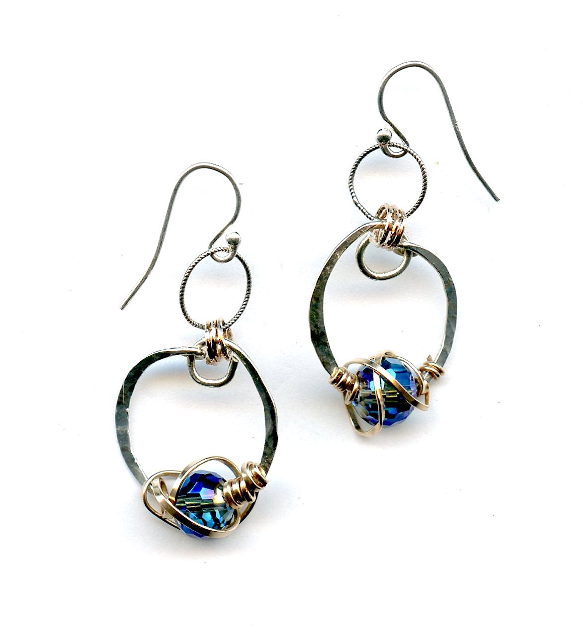 blue crystal built in to a mini sterling silver mini hoop earring wrapped up in bronze wire hanging from a braided link