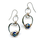 blue crystal built in to a mini sterling silver mini hoop earring wrapped up in bronze wire hanging from a braided link