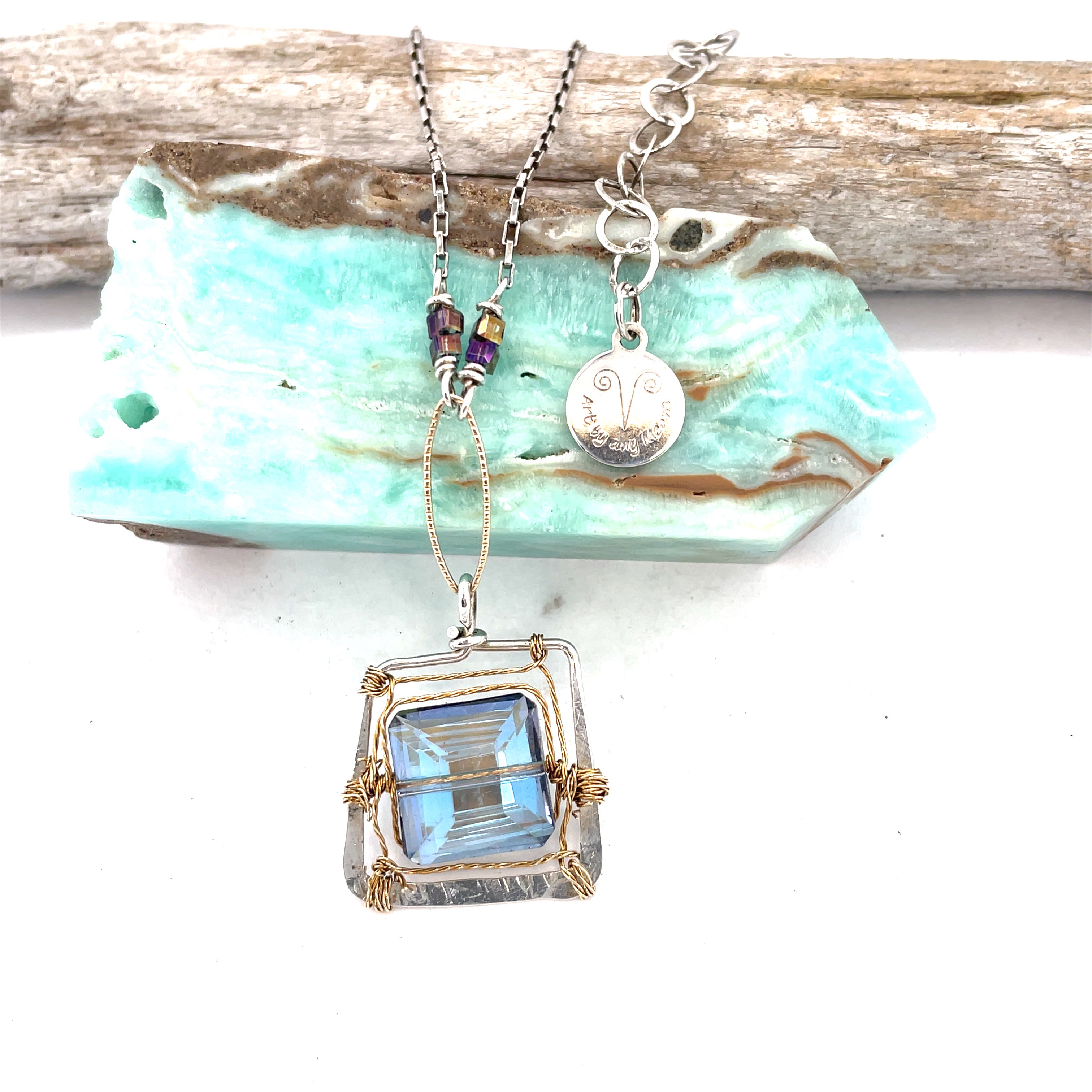 Blue crystal tile lined in brass twist wire layers in a hammered handmade sterling silver box pendant, with crystal cube and gold fill link accents on a sterling silver chain
