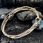 Handmade stamped brass skinny bracelet braided with oxidized sterling silver and gold filled wires
