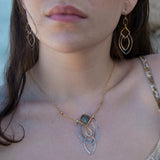 Sterling silver double teardrops swinging from stamped brass diamonds, all hanging from a braided brass link