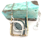 London blue quartz, pyrite, bloodstone, and blue tourmaline gemstones sit within a brass box pendant with sterling silver and gold filled wire accents on a sterling silver box chain