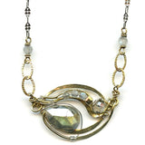 A brass hammered pendant with flashy moonstone, labradorite gemstones, and crystal with gold filled textured links on a sterling silver delicate chain necklace