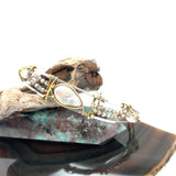 Fresh water pearl with labradorite faceted gemstones and clear quartz cubes are held within gold filled and brass wire attached to a skinny sterling silver handmade bracelet