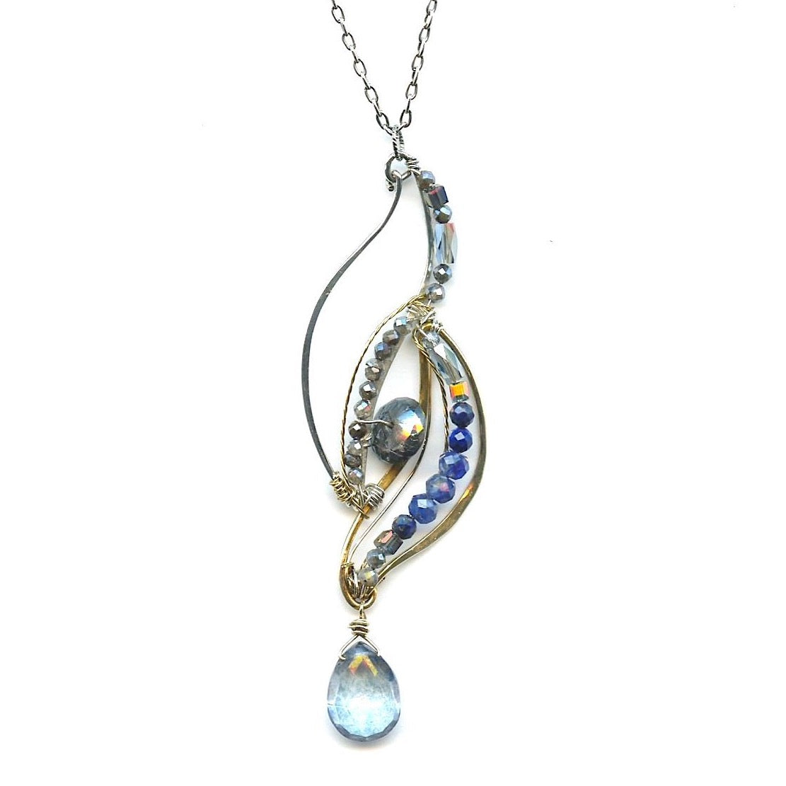 Sterling silver and brass wing shapes combined to make one pendant featuring moonstone, blue crystal, labradorite, kyanite, and lapis gemstones with a blue quartz hanging drop to complete the necklace